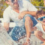 father and children happy at swimming pool