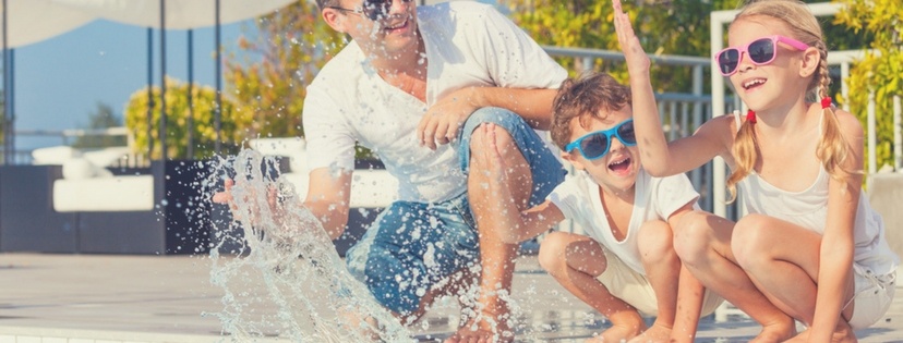 father and children happy at swimming pool