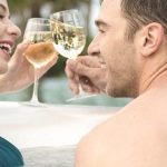 happy couple relax and drink at hot tub