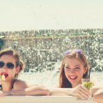 fun girls drink juice at the hot tub