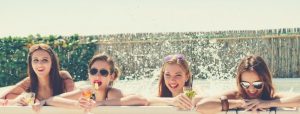 fun girls drink juice at the hot tub