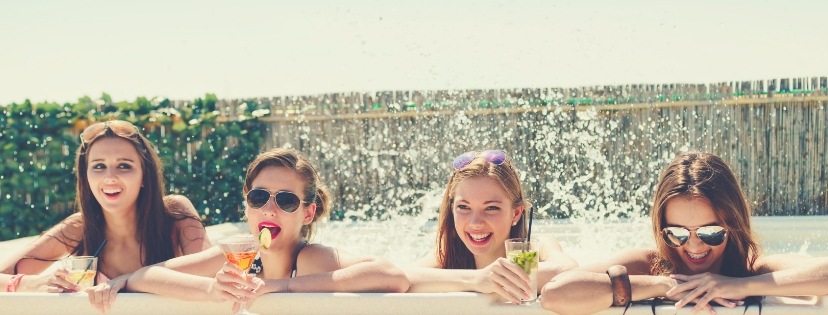 fun girls drink juice at the hot tub